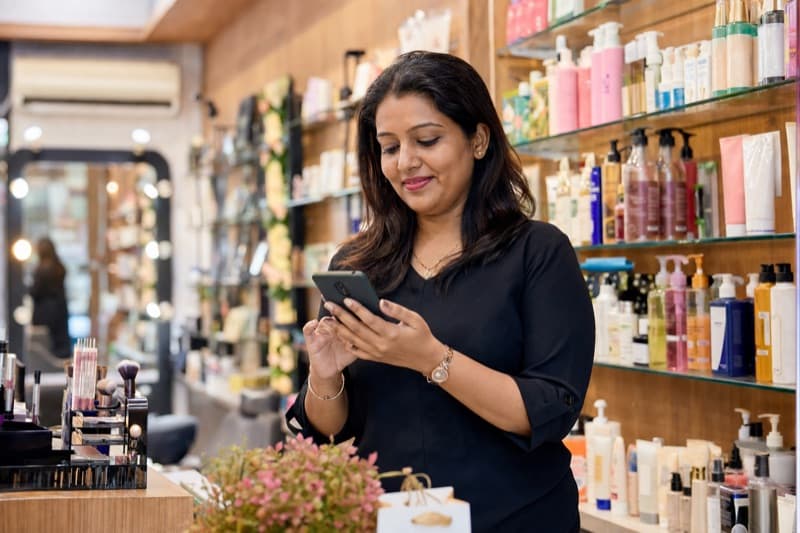 Beauty shop owner using Bee-Hive supply chain platform on mobile